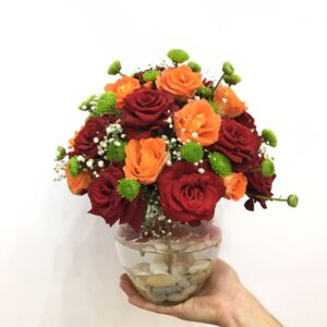 Red and orange roses in Vase - A group of red and orange roses in a cute vase